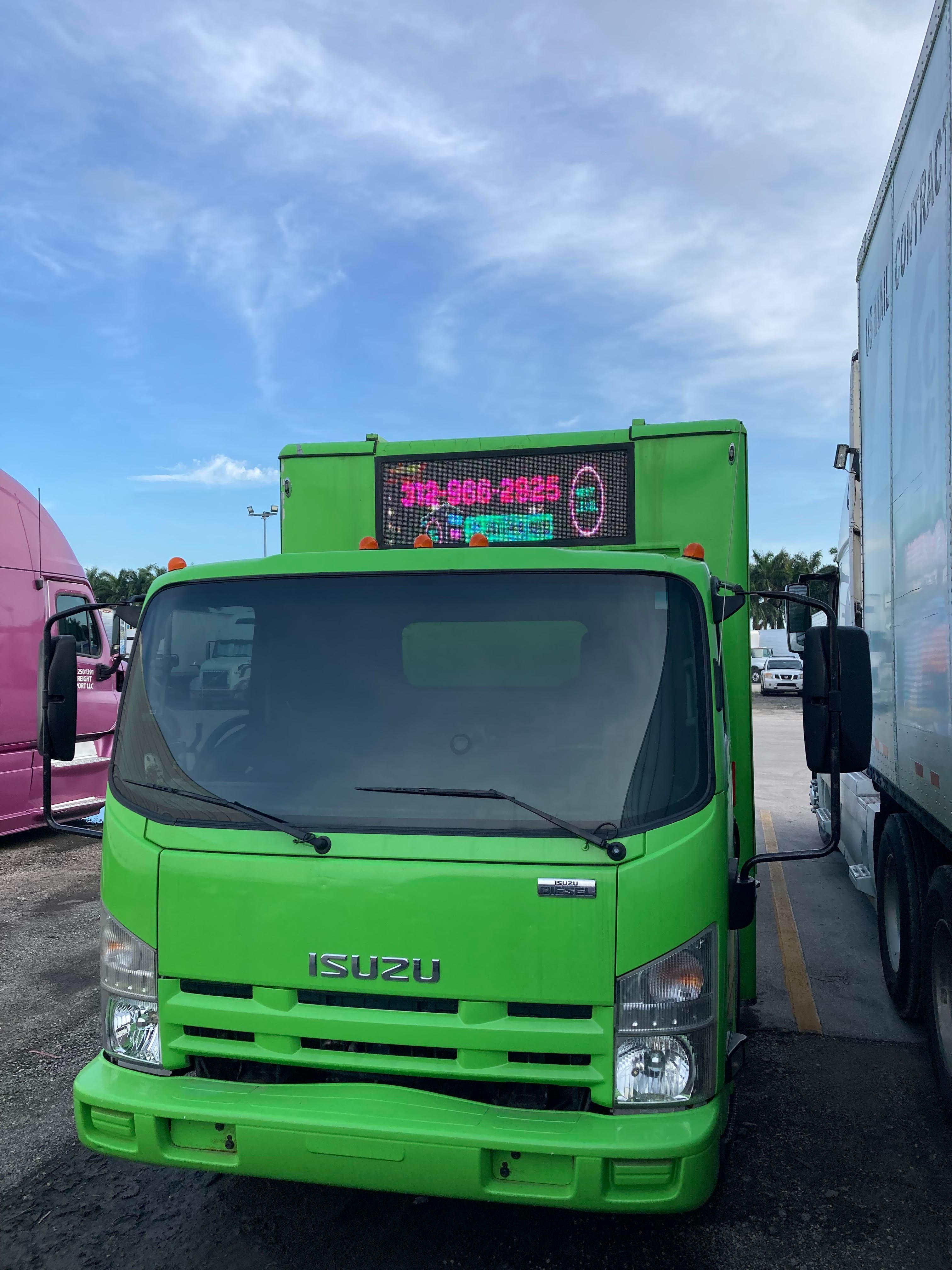 green truck with billboard in it 